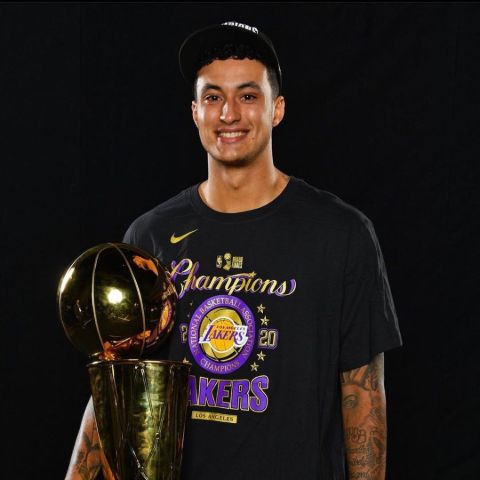 Kyle Kuzma poses a picture with NBA trophy.